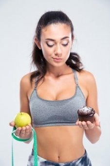 Brunette Contemplating Whether To consume Muffin or Apple